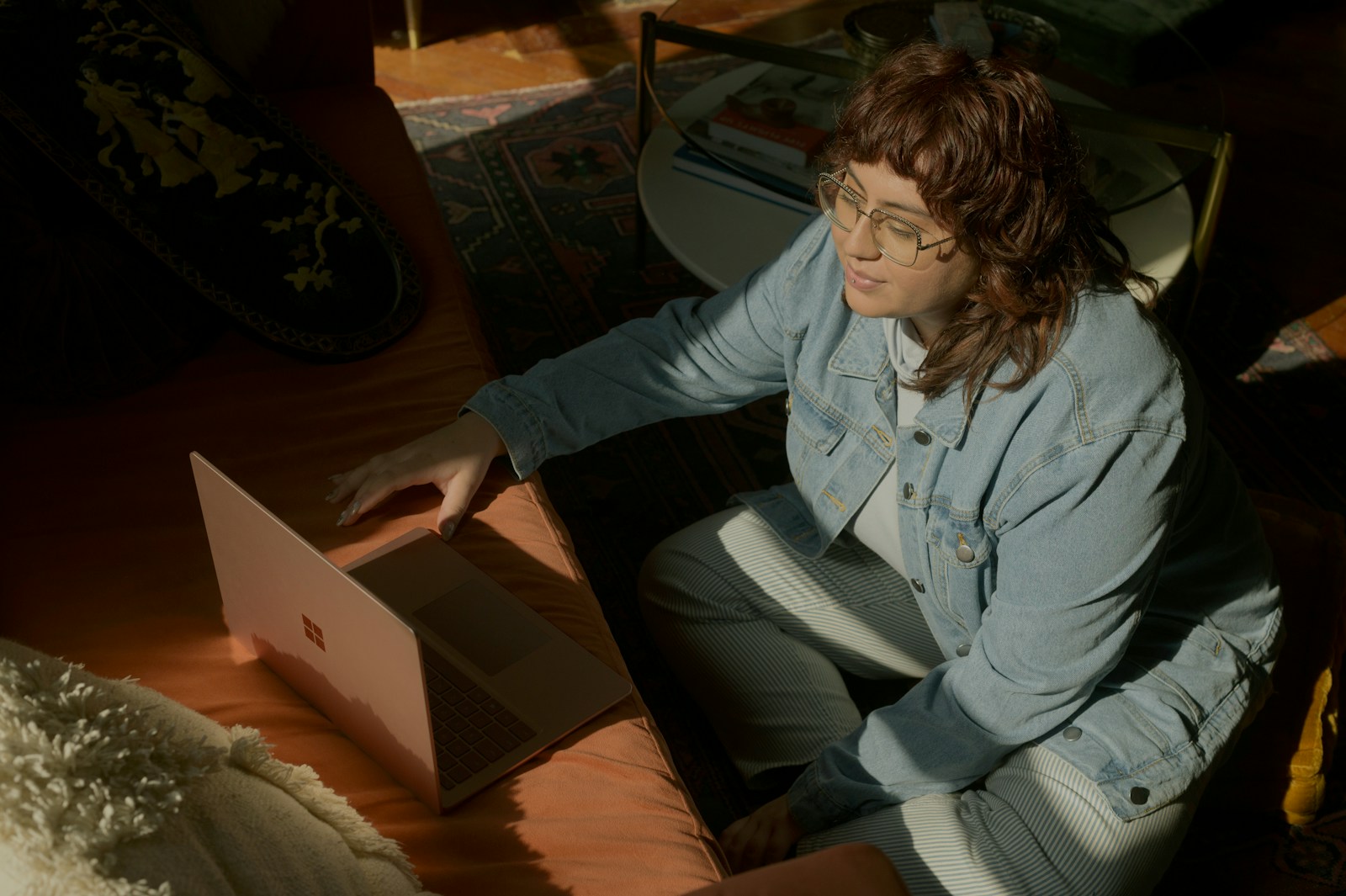 a woman sitting at a table using a laptop computer